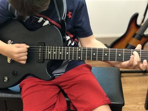 Beginner guitar student learning the ropes with guitar teacher Ethan Wing